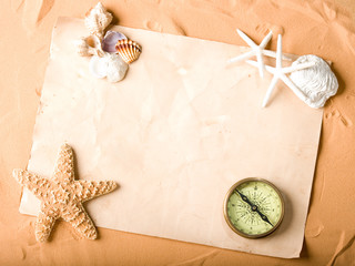 Wall Mural - old paper and compass on sand background