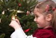 Cheerful little girl view the ornaments of a Christmas tree