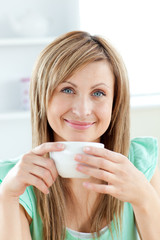 Canvas Print - Bright woman holding a cup of coffee in the kitchen