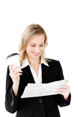 Canvas Print - Beautiful businesswoman holding a cup of coffee reading a newspa