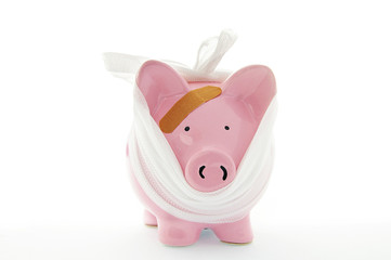 piggy bank with bandage on white