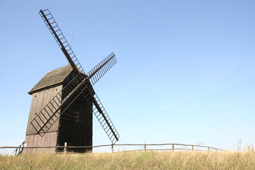 Wall Mural - Old windmill (trestle type) in a field with a fence