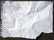 Crumpled and torn perforated paper sheet isolated on black
