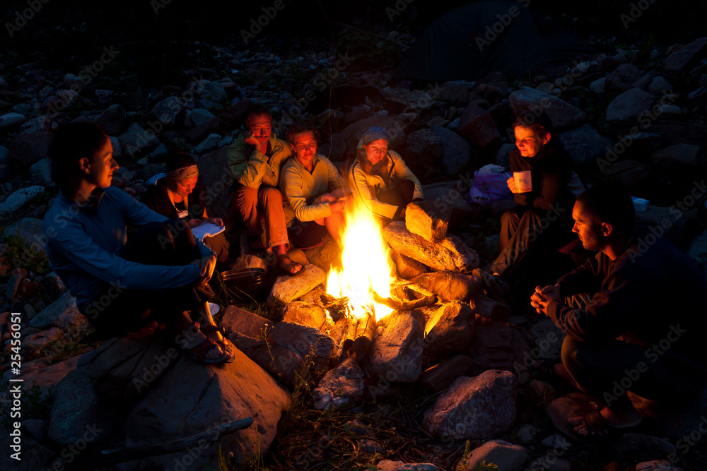 People near campfire in forest. - obrazy, fototapety, plakaty 