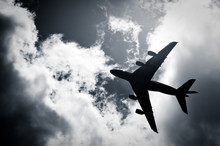 Large Passenger Jet Silhouette Against Clouds