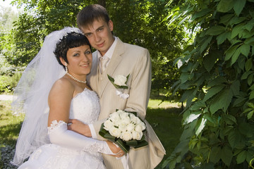 The groom and the bride on walk in park