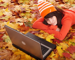 Wall Mural - girl in autumn orange leaves with laptop.fall sale.