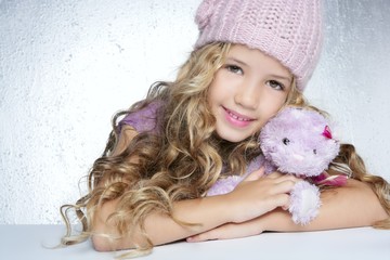 Wall Mural - winter fashion cap little girl hug teddy bear smiling