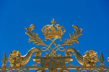 Detail Of Golden Door Of Versailles Palace Under Blue Sky