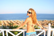 © Nomad_Soul - Young woman in glasses on balcony