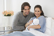 © JGI/Blend Images - Hispanic couple holding newborn baby in hospital bed