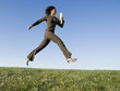 © Erik Isakson/Blend Images - Mixed race businesswoman leaping in field