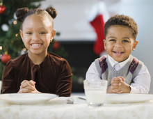 African American Brother And Sister Sitting At Table