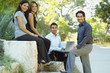 © Karin Dreyer/Blend Images - Hispanic business people using laptop outdoors