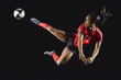 © Erik Isakson/Blend Images - Mixed race soccer player kicking soccer ball in mid-air