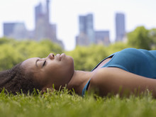 African Woman Laying On Grass In Park