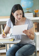 © JGI/Tom Grill/Blend Images - Hispanic woman doing homework in classroom