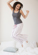 © JGI/Jamie Grill/Blend Images - Mixed race woman jumping on bed