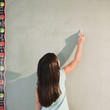 © JGI/Jamie Grill/Blend Images - Mixed race girl writing on blackboard