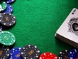 Poker chips & cards on green felt background