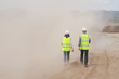 © Chris Sattlberger/Blend Images - Construction workers walking in cloud of dust