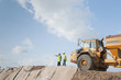 © Chris Sattlberger/Blend Images - Hispanic construction workers in field with dump truck