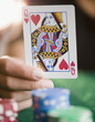 © JGI/Jamie Grill/Blend Images - Hand holding queen of hearts playing card