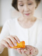 © JGI/Jamie Grill/Blend Images - Japanese woman pouring medicine into hand