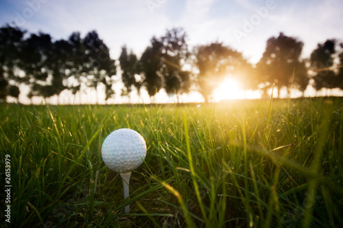 Board z aluminiowym obramowaniem Piłeczka golfowa na tee na kurs złotej o zachodzie słońca