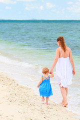 Wall Mural - Mother and baby walking along tropical beach