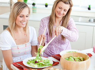 Sticker - Two delighted women eating salad in the kitchen