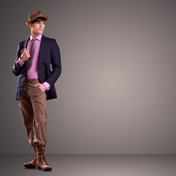 Attractive man dresed in stylish clothes on gray background