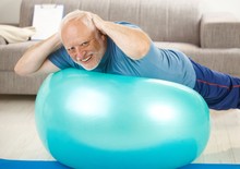 Active Senior Doing Exercises On Gym Ball