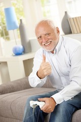 Canvas Print - Older man giving thumb up with computer game