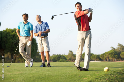Board z aluminiowym obramowaniem Grupa golfistów płci męskiej teeing off na pole golfowe