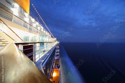 Fotomural big illuminated cruise ship riding in evening. wide angle.