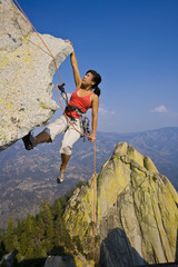 Wall Mural - Female rock climber rappelling.