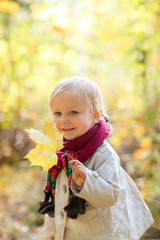 Canvas Print - Toddler girl holding yellow leaf