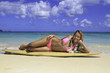 girl in pink bikini at the beach in hawaii with her surfboard
