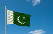 Flag of Pakistan waving in the wind in front of blue sky