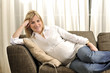 © uwimages - Waiting for the baby - Pregnant woman lying on a sofa.