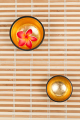 Two golden bowls on the bamboo mat