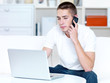 © Valua Vitaly - man speaks on the phone and laptop