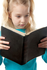 little blonde girl is reading the Holy Bible