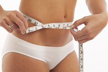Young Woman In Underwear With Measuring Tape
