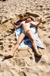 © travelview - boy and girl at the beach digging in the sand
