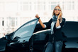 Fashion business woman calling on phone next to her car