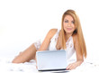 © Acronym - A young and beautiful woman is working in the bed