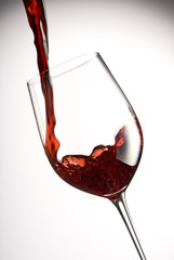 pour red wine into a glass with white background