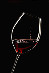 glass of red wine with a black background